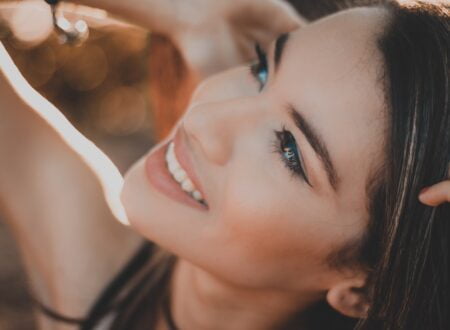 femme souriante aux cheveux noirs et au rouge à lèvres rouge