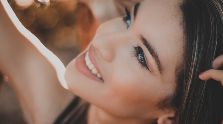 lachende vrouw met zwart haar en rode lippenstift